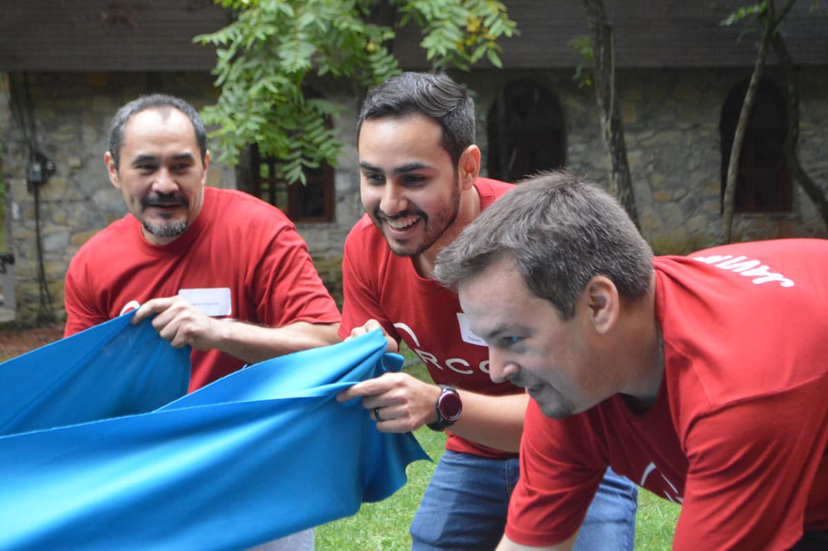 Equipo riendo mientras completan una actividad de integración, destacando la diversión y el aprendizaje colaborativo