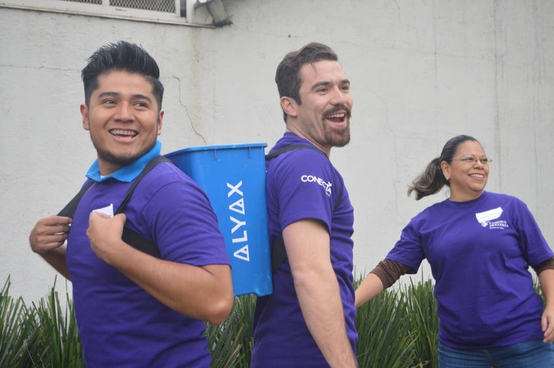 Colaboradores chocando las manos al finalizar una actividad, celebrando la integración lograda durante el rally