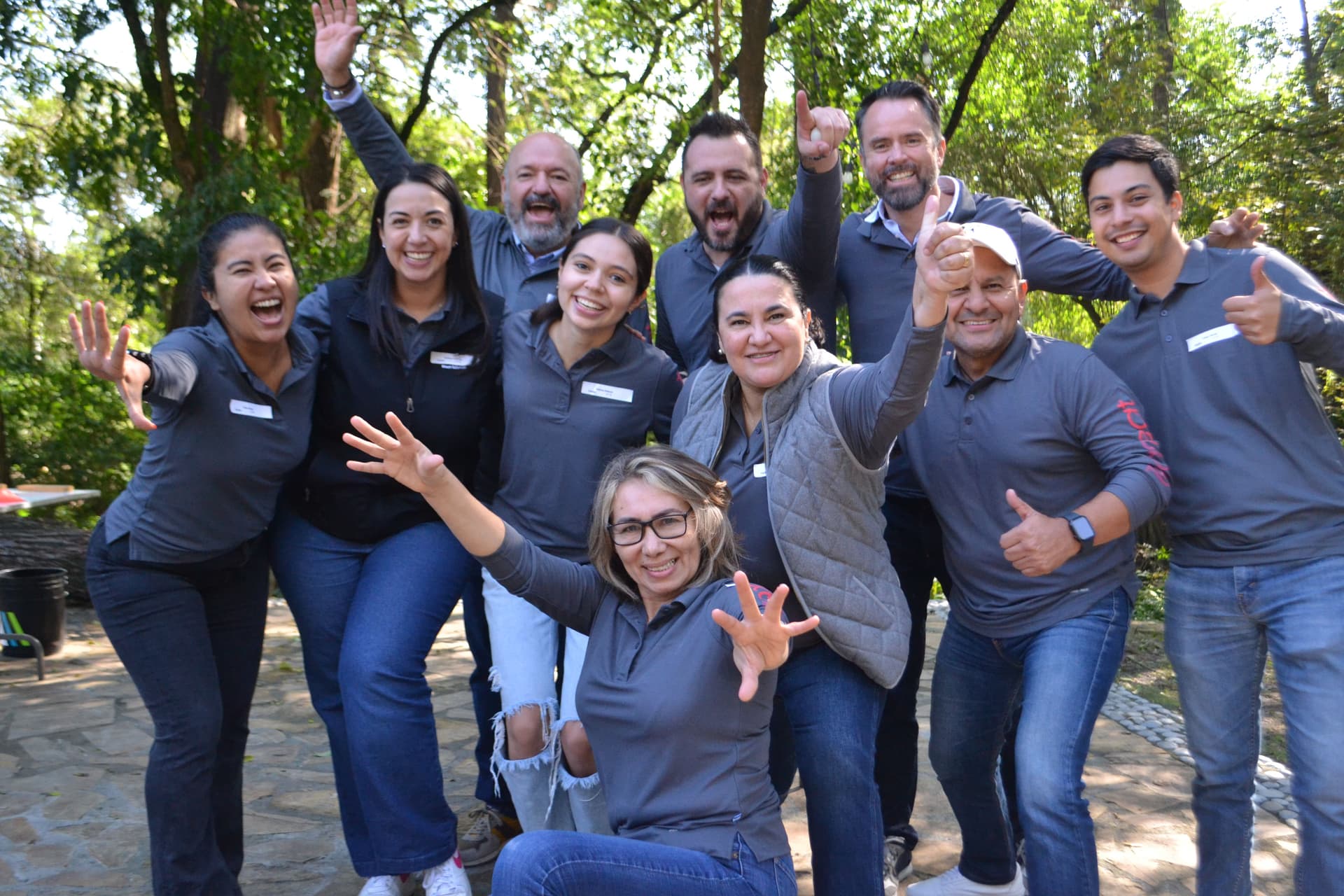 Equipo posando juntos y sonriendo al final de la actividad, celebrando la unión y el logro en el rally empresarial